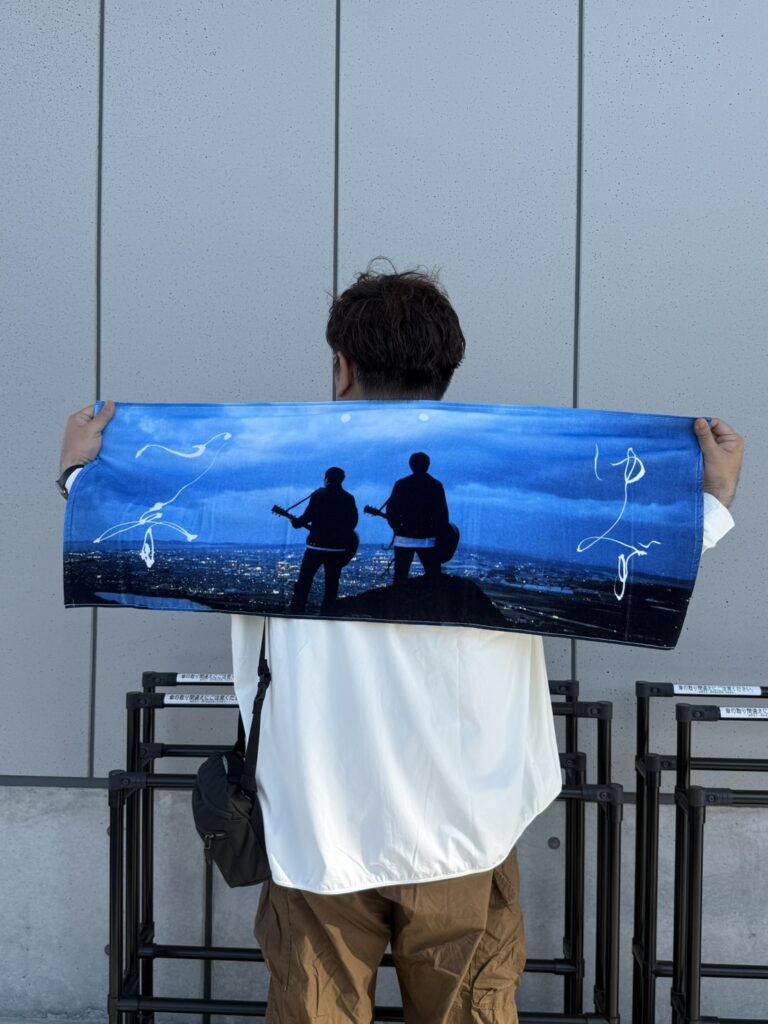 ゆずライブの記念に購入したマフラータオルを手にする筆者