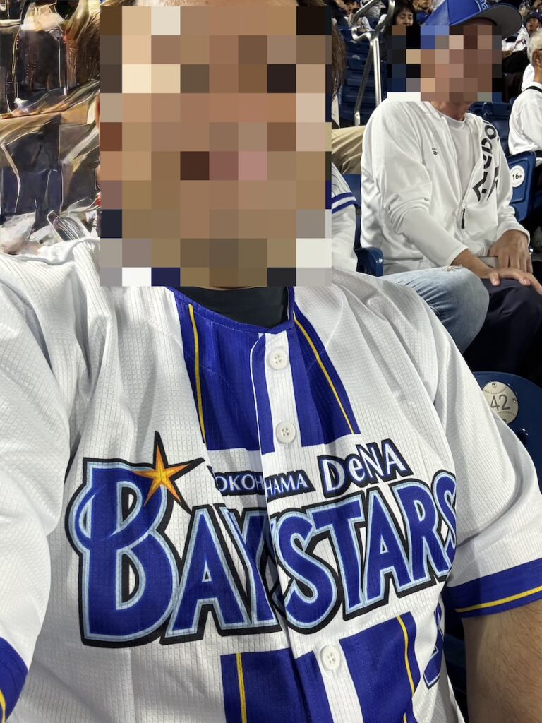 横浜スタジアムの観客席で横浜DeNAベイスターズのユニフォームを着て野球観戦を楽しむ50代男性